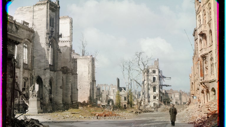 A colour image of a man walking through the the post-war ruins of Cologne in 1946